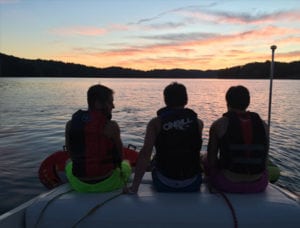 three men enjoying sunset from back of boat on Norris Lake