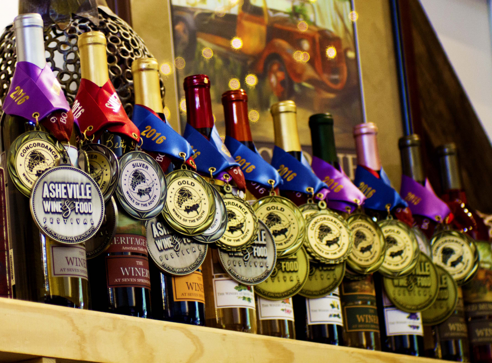 Wine bootles with award medals around the necks.